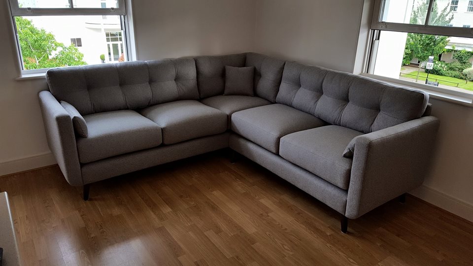 Modern corner sofa upholstered with gray fabric