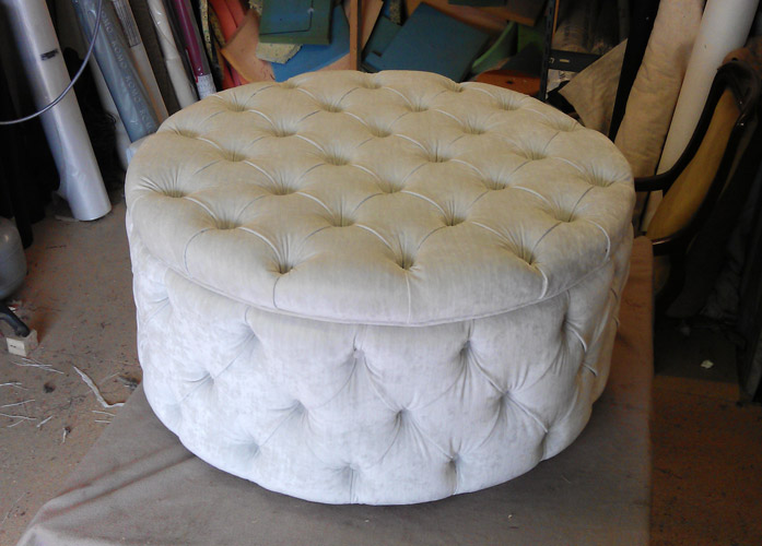 Round pouf upholstered with soft fabric