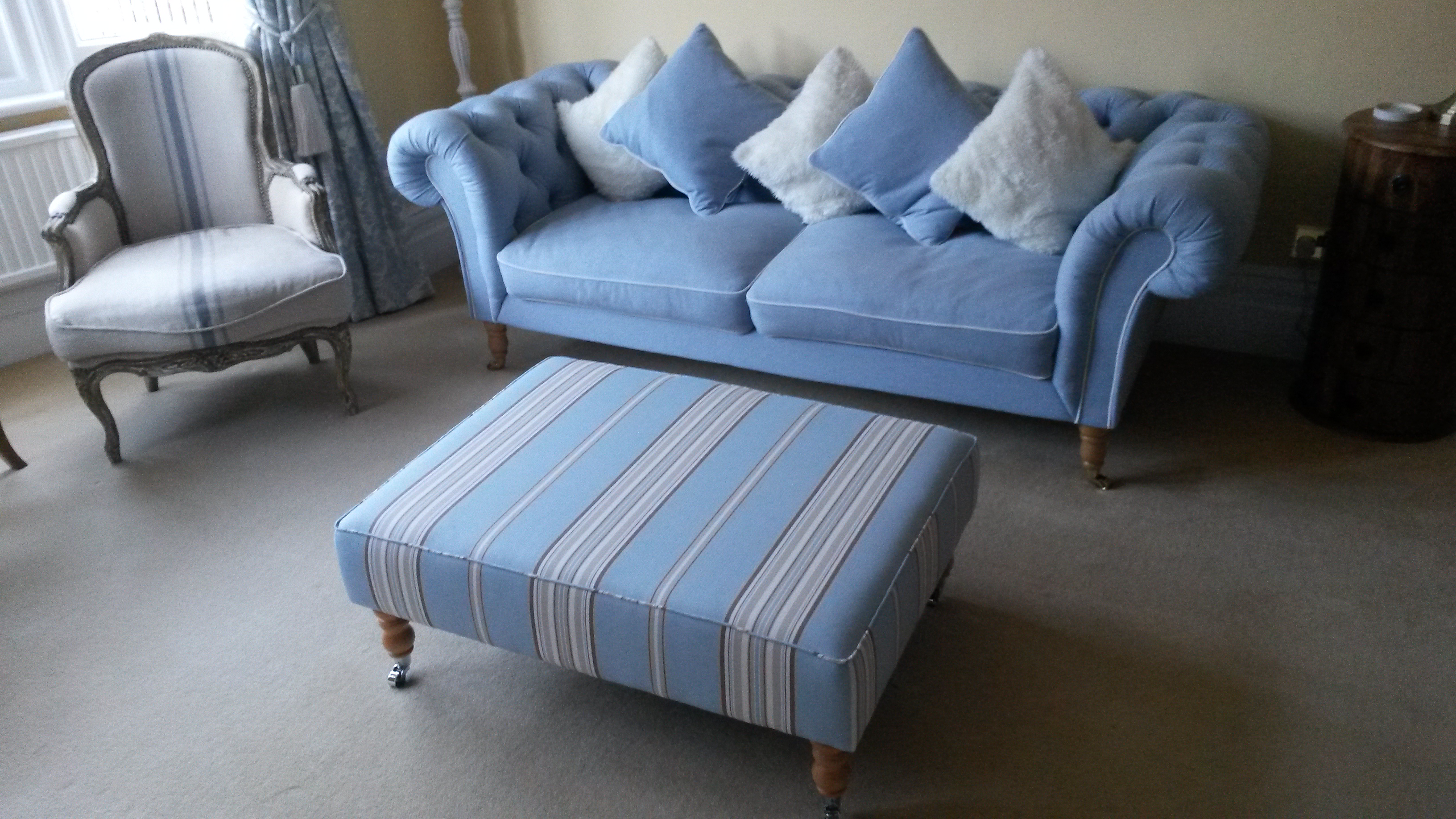 Sofa with cusions and footrest upholstered with light blue fabric