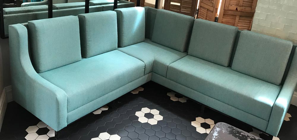 Modern corner sofa upholstered with light green fabric